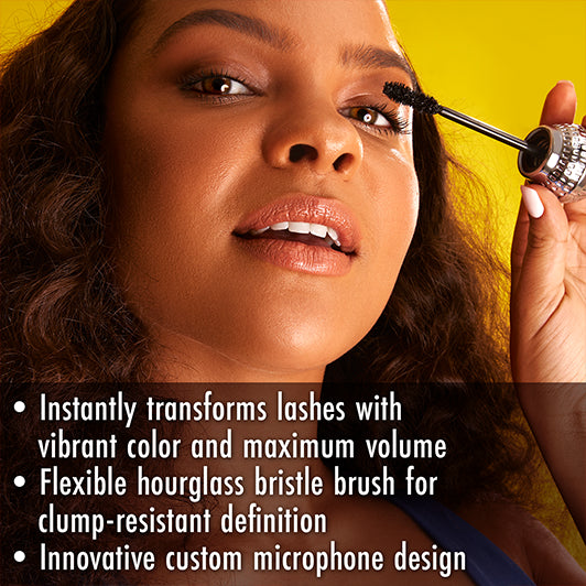 Model applying Black Radiance x Cross Colours mascara with product benefits listed: vibrant volume, clump-resistant hourglass brush, and mic-shaped wand.