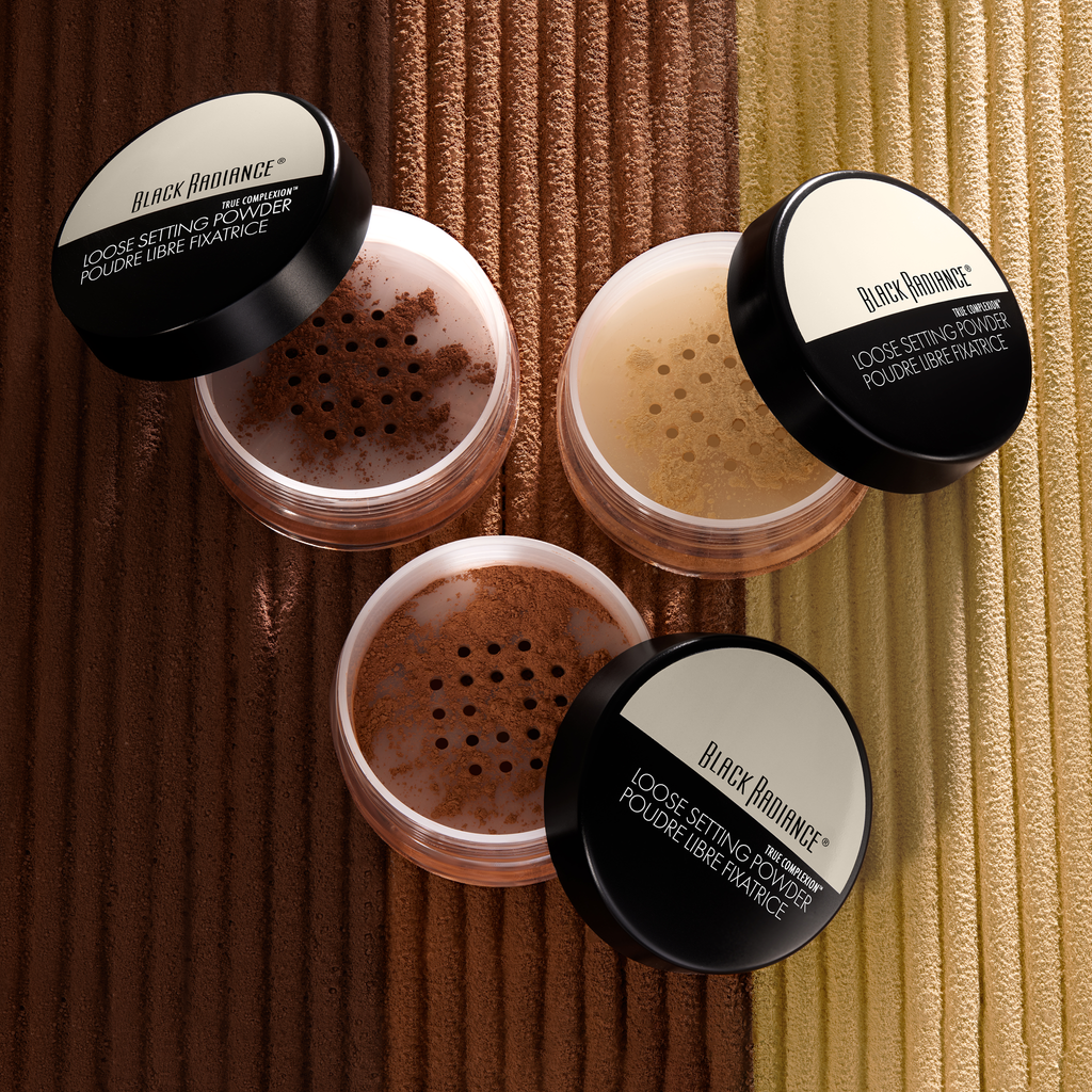 Black Radiance loose setting powders in various shades on a textured background