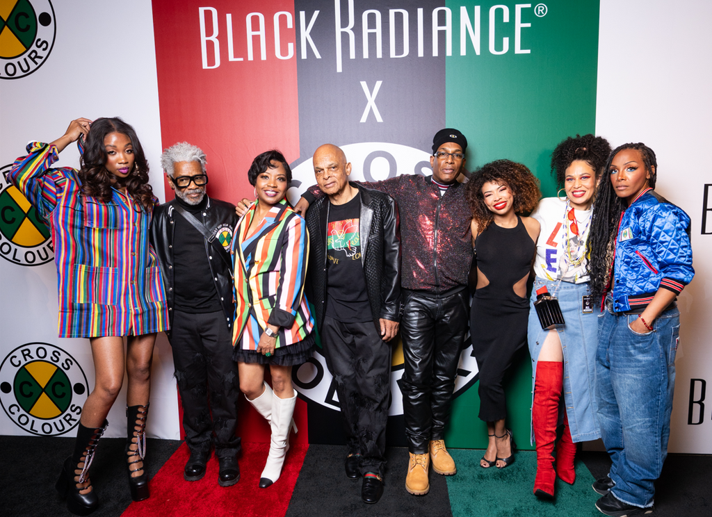 Group photo at the Black Radiance x Cross Colours launch event, featuring founders, collaborators, and guests posing in front of a branded step-and-repeat backdrop